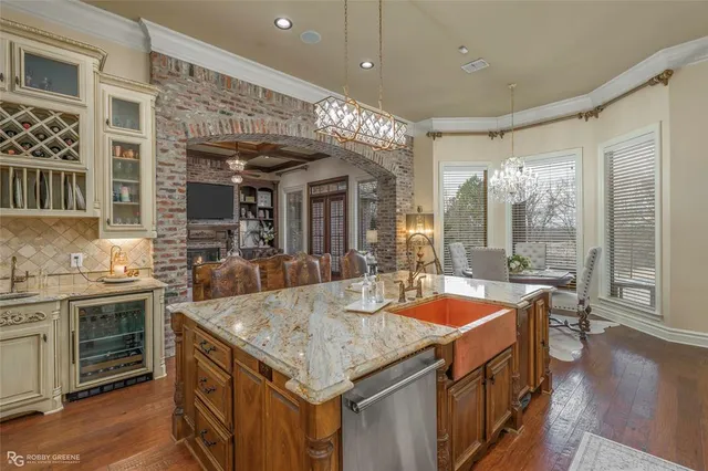 a dining hall with stainless steel appliances granite countertop a sink and cabinets