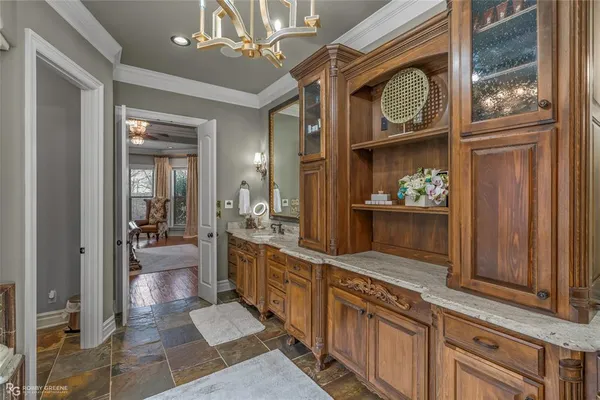 a bathroom with a granite countertop toilet a sink a mirror a bathtub and shower