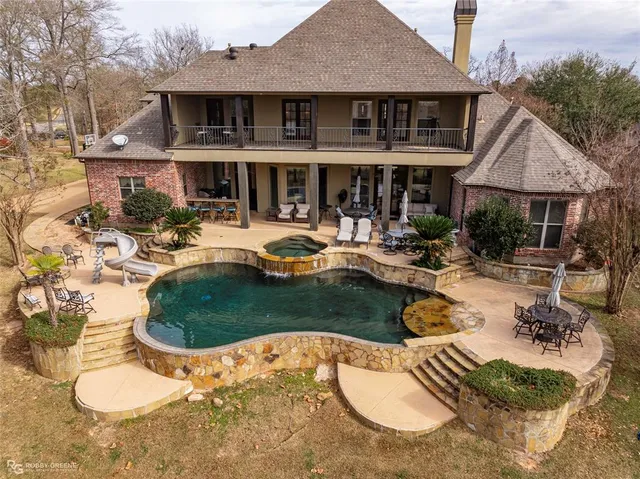 a view of a house with swimming pool and sitting area