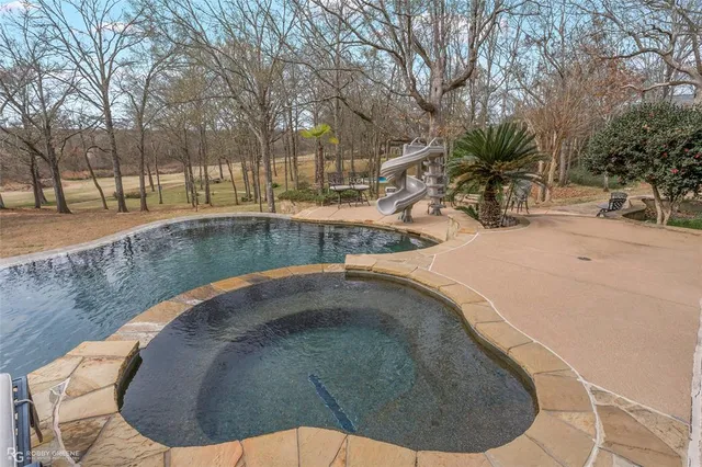 a view of a swimming pool with a lawn chairs and a fire pit