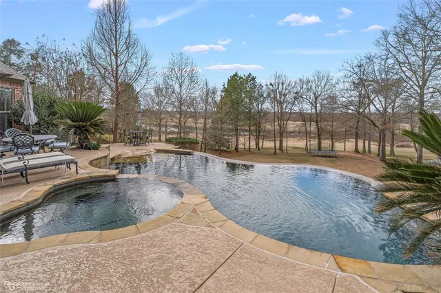 a swimming pool with outdoor seating and yard