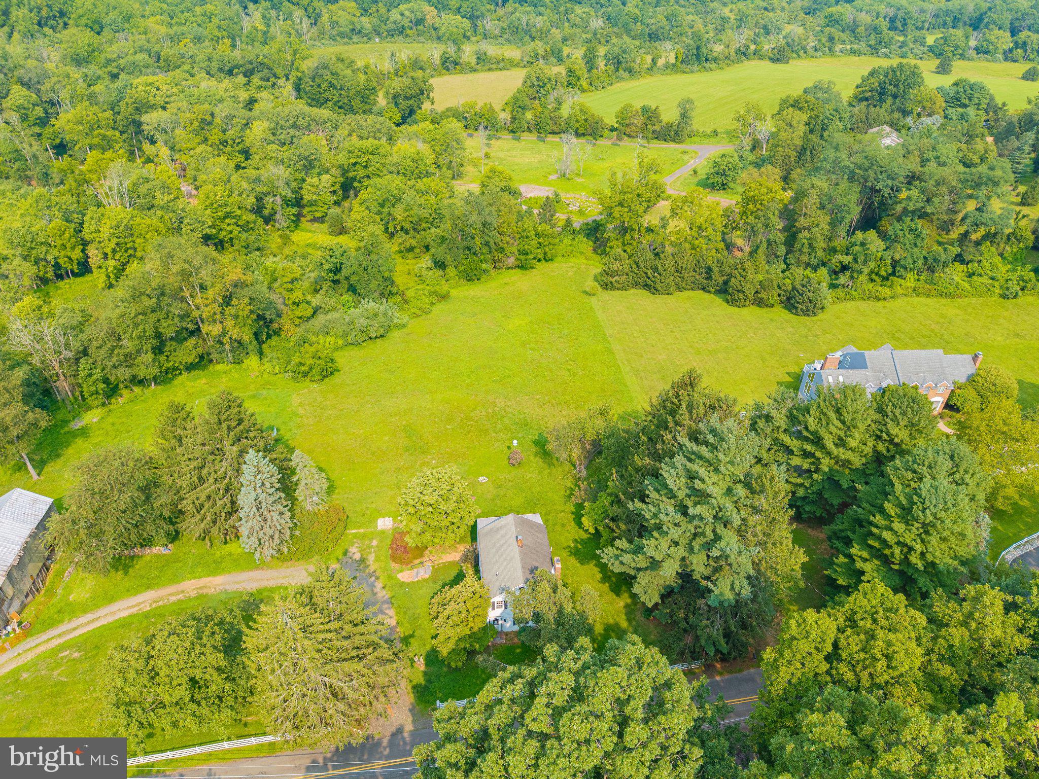 67 Poor Farm Road Pennington, NJ 08534 - Photo 7 of 33 Lush greenery surrounds a serene home.