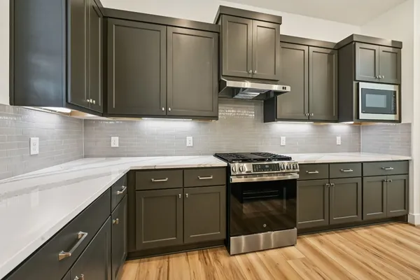 a kitchen with stainless steel appliances granite countertop a sink stove and refrigerator