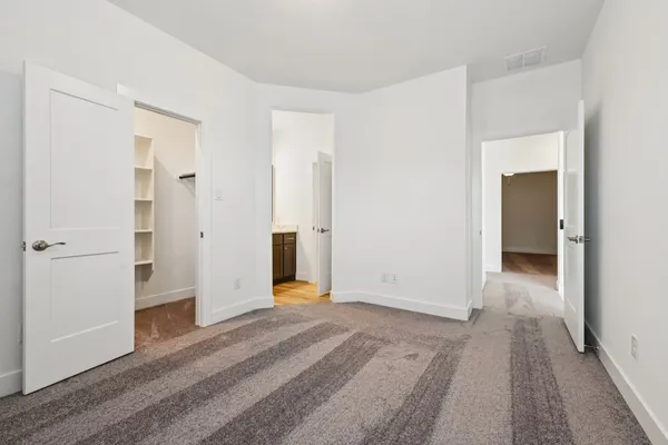 a view of a room with wooden floor and a bathroom