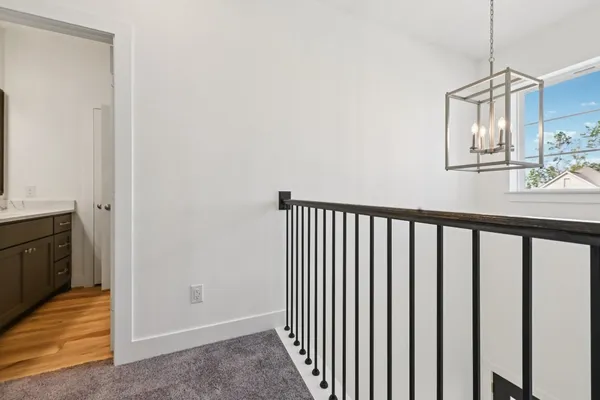 a view of a hallway with wooden floor and staircase