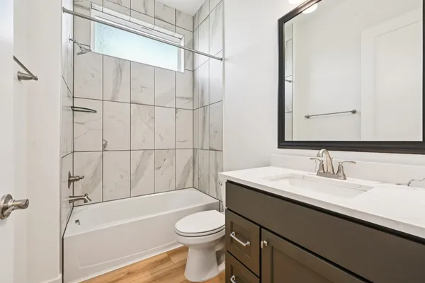 a bathroom with a sink a toilet and shower