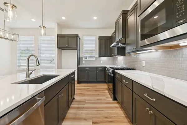 a kitchen with stainless steel appliances a sink stove and refrigerator