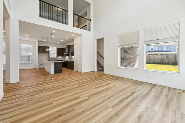 a view of a living room and kitchen space with wooden floor