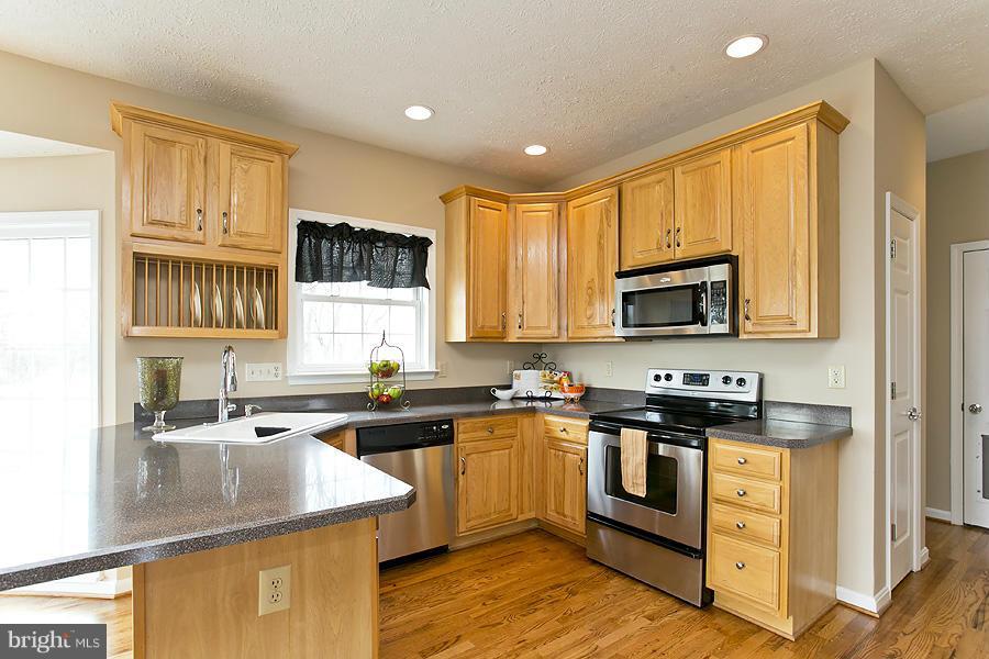176 White Hall Road Winchester, VA 22603 - Photo 10 of 30 a kitchen with stainless steel appliances granite countertop a sink stove and refrigerator