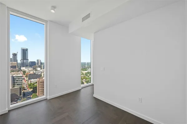 an empty room with wooden floor and a window