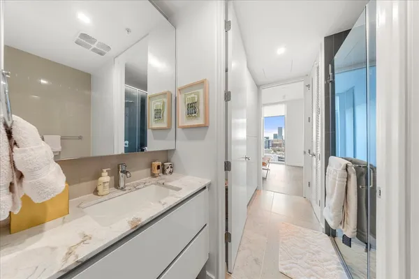 a bathroom with a sink double vanity granite and a shower