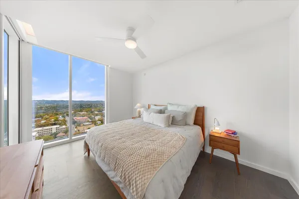 a bedroom with a bed and a large window