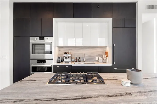 a kitchen with a stove a sink and a window