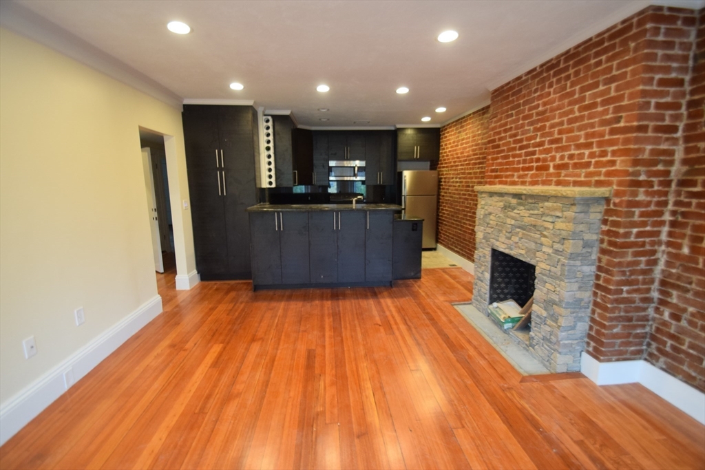 1616 Beacon Street, Unit 2 Brookline, MA 02446 - Photo 2 of 9 a view of kitchen with kitchen island wooden floor and living room