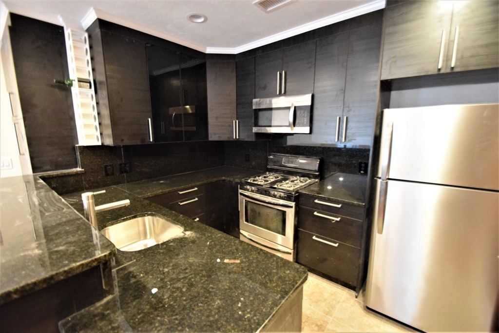 1616 Beacon Street, Unit 2 Brookline, MA 02446 - Photo 3 of 9 a kitchen with granite countertop a refrigerator stove and sink