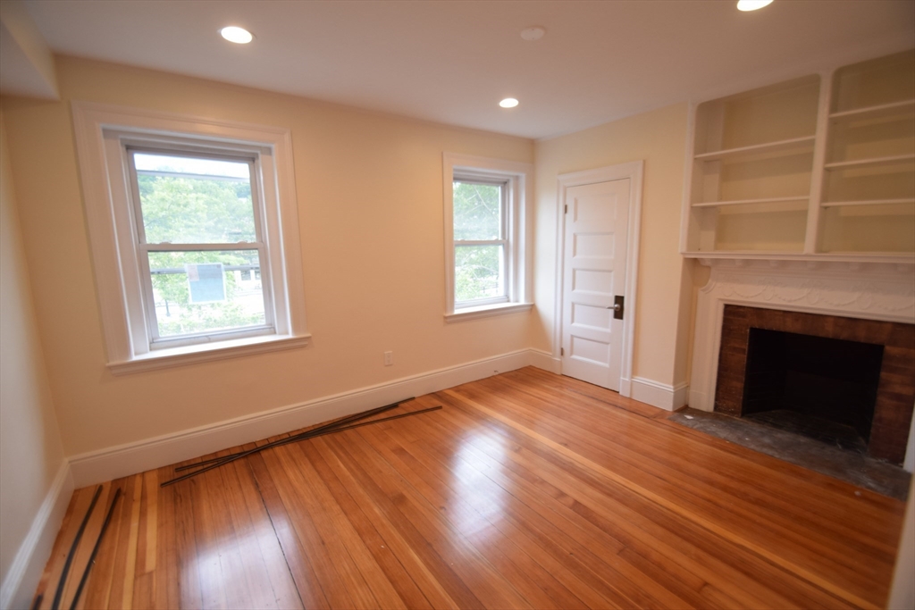 1616 Beacon Street, Unit 2 Brookline, MA 02446 - Photo 7 of 9 a view of an empty room with wooden floor and a window