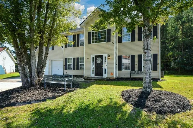 a view of a house with backyard and sitting area
