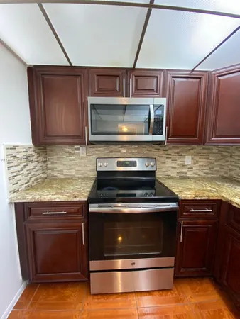 a kitchen with granite countertop a stove and a microwave