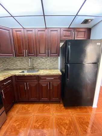 a kitchen with a refrigerator and a sink