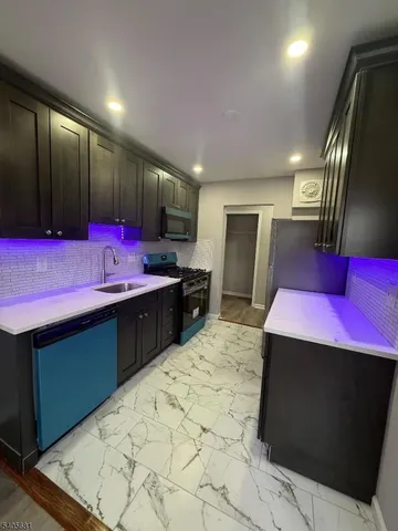 a kitchen with stainless steel appliances kitchen island granite countertop a refrigerator a sink dishwasher with a dining table and chairs