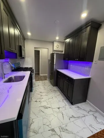 a kitchen with stainless steel appliances kitchen island granite countertop a sink and cabinets