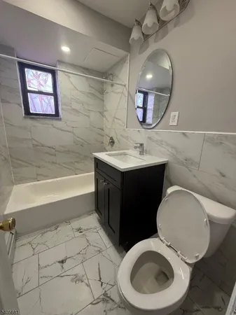 a bathroom with a toilet a sink and mirror