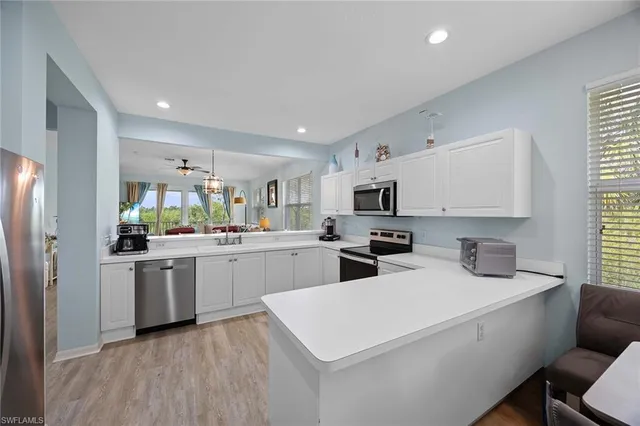 a kitchen with white cabinets and white appliances