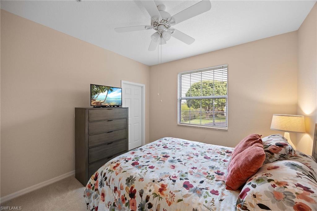 8365 Whisper Trace Way, Unit L204 Naples, FL 34114 - Photo 21 of 45 a bedroom with a bed and a chandelier