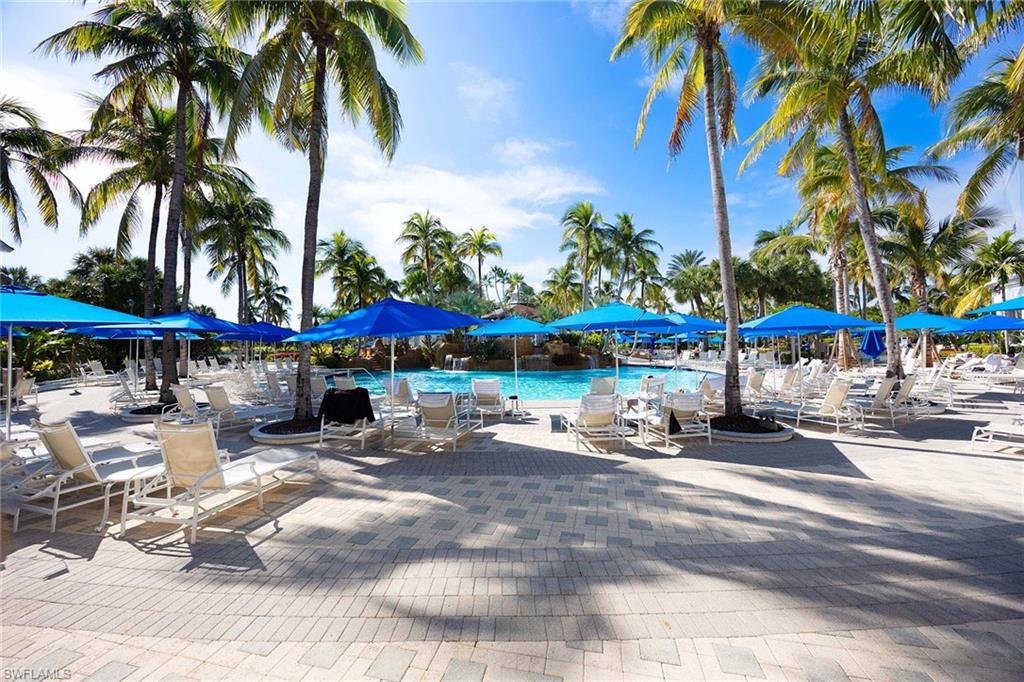 8365 Whisper Trace Way, Unit L204 Naples, FL 34114 - Photo 33 of 45 a view of a patio with a table and chairs under an umbrella with a patio