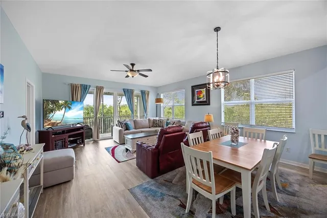 a view of a dining room and livingroom with furniture wooden floor a chandelier