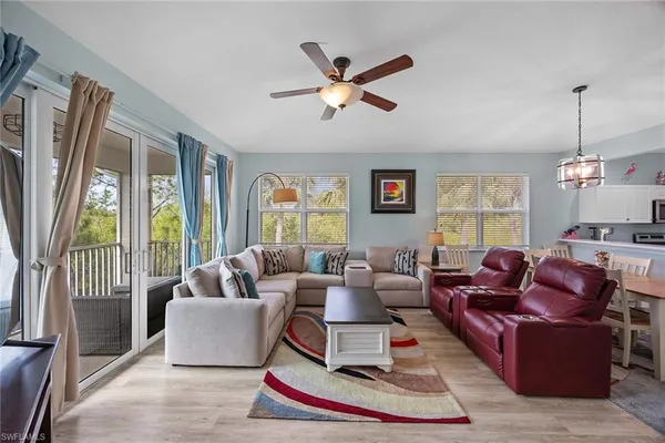 a living room with furniture ceiling fan and a window