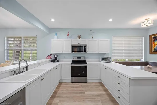 a kitchen with white cabinets and a stove