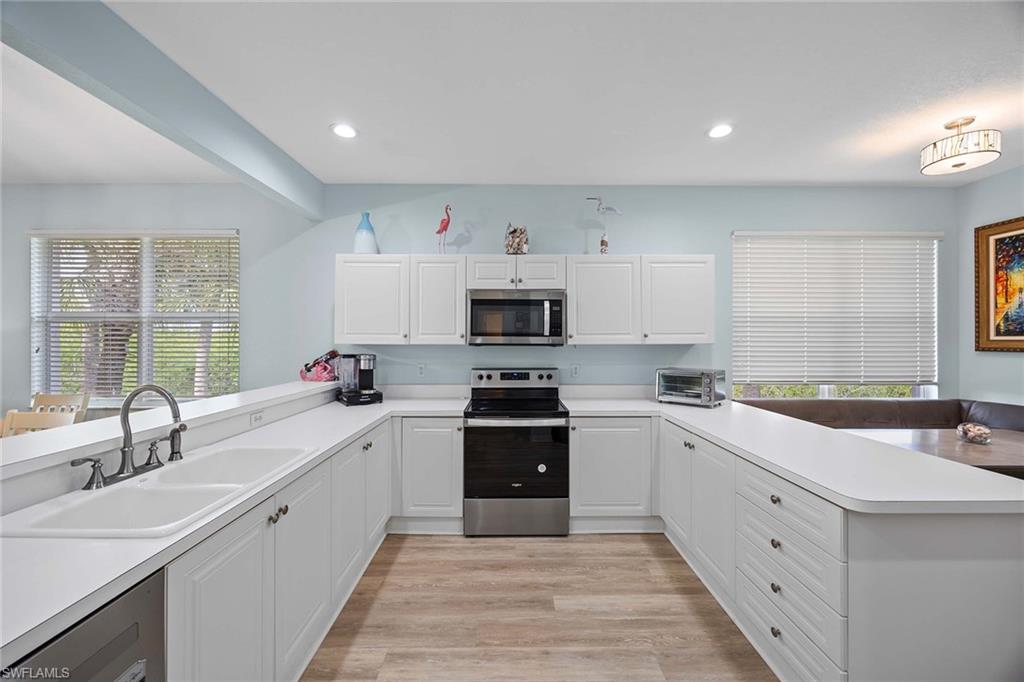8365 Whisper Trace Way, Unit L204 Naples, FL 34114 - Photo 10 of 45 a kitchen with white cabinets and a stove