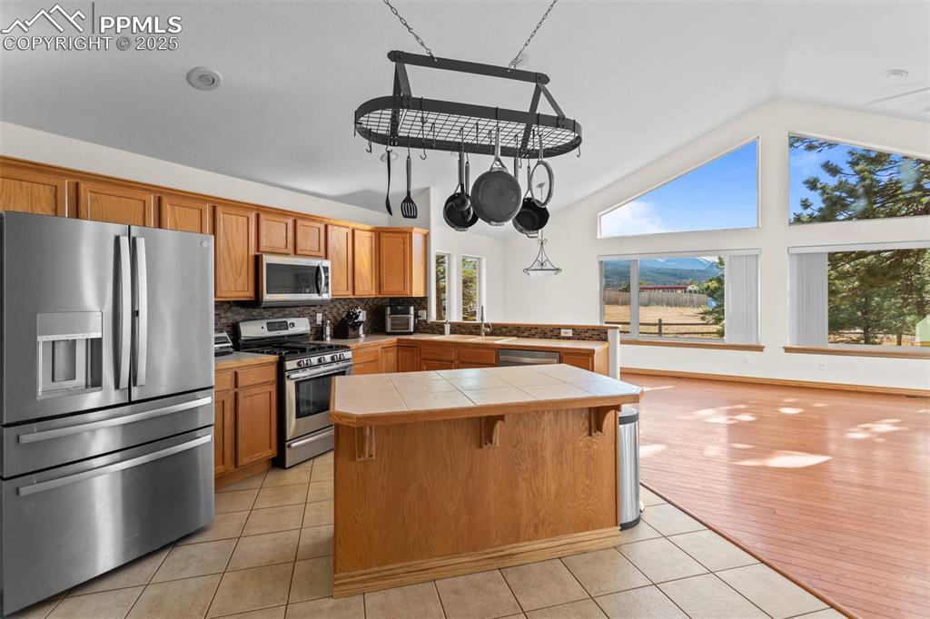162 Ridge Top Drive Divide, CO 80814 - Photo 11 of 50 a kitchen with stainless steel appliances granite countertop a sink a stove top oven a refrigerator cabinets and a window
