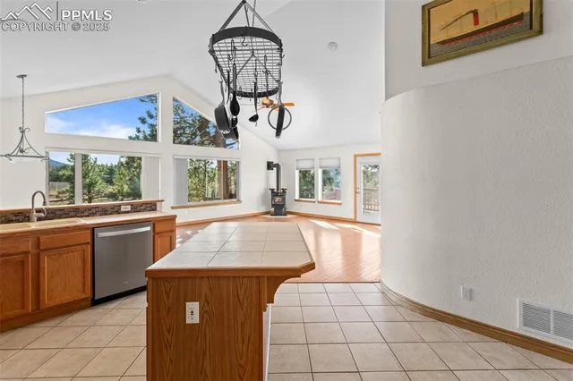 a kitchen with kitchen island granite countertop a stove a sink a counter space and cabinets