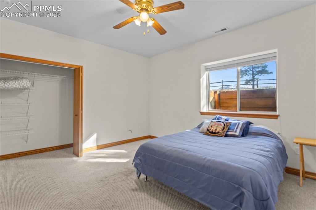 162 Ridge Top Drive Divide, CO 80814 - Photo 26 of 50 a bedroom with a bed and a chandelier