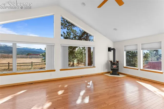 a view of an empty room with a window and wooden floor
