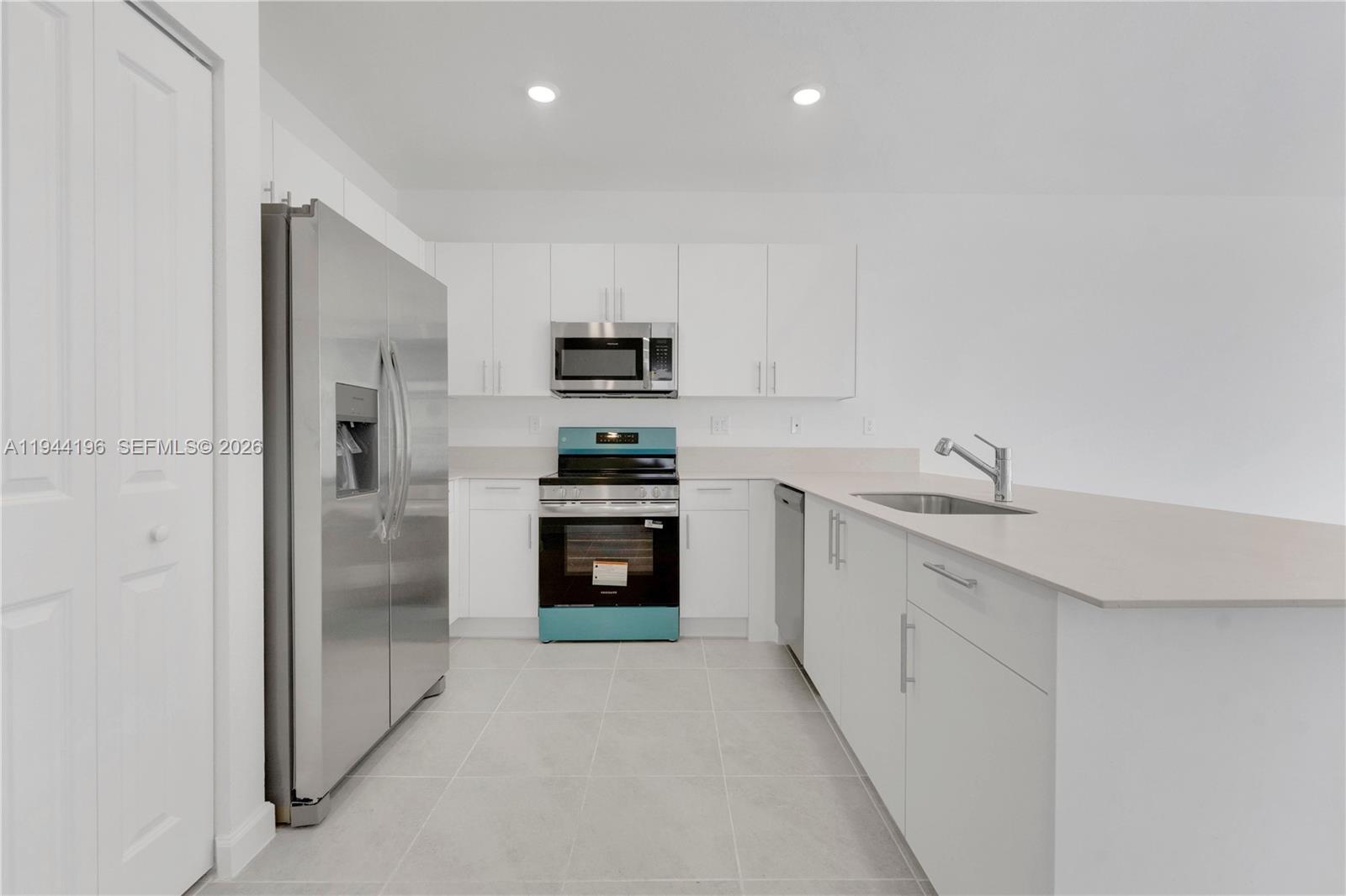 12168 Southwest 268th Street Homestead, FL 33032 - Photo 7 of 27 a kitchen with stainless steel appliances granite countertop a refrigerator sink and stove