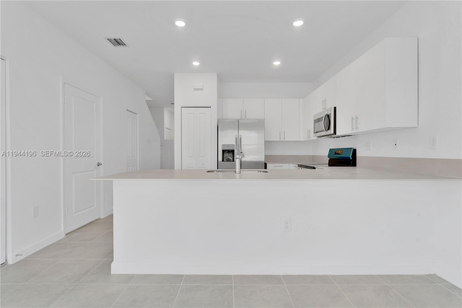 12168 Southwest 268th Street Homestead, FL 33032 - Photo 8 of 27 a view of kitchen with kitchen island sink and refrigerator