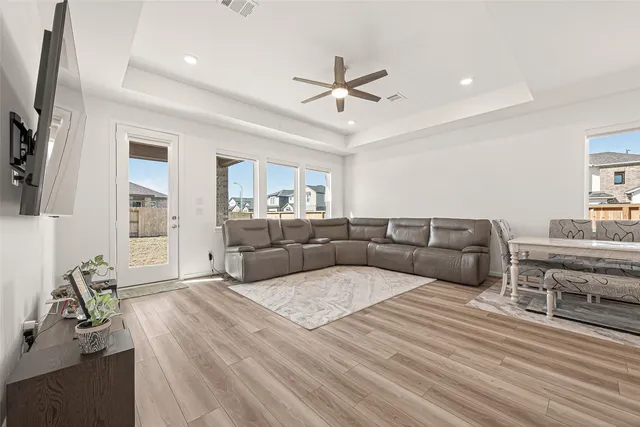 a living room with furniture a ceiling fan and a rug
