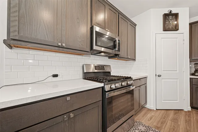 a kitchen with stainless steel appliances granite countertop a sink stove and microwave