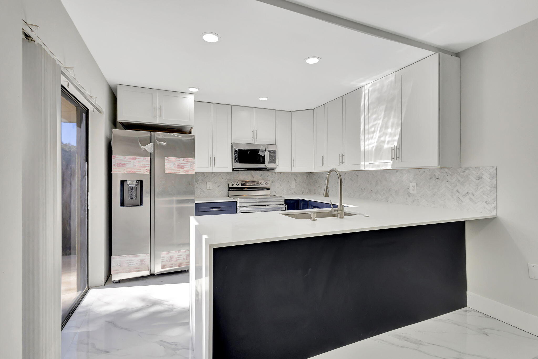 318 3rd Way West Palm Beach, FL 33407 - Photo 10 of 26 a kitchen with stainless steel appliances a sink stove refrigerator and cabinets