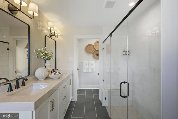 a bathroom with a double vanity sink mirror and shower