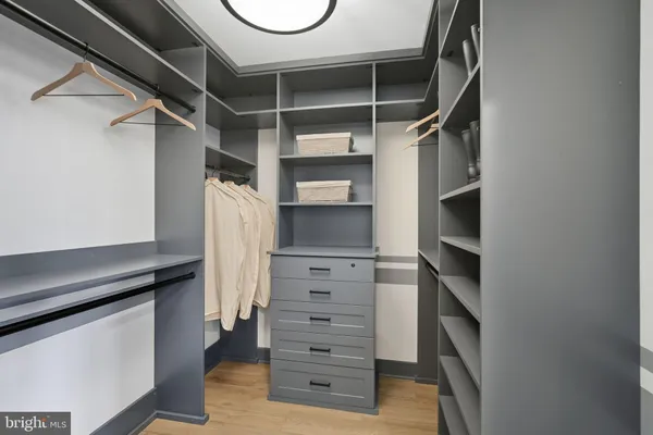 a view of walk in closet with clothes and shoes