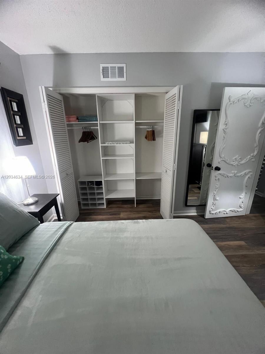 9880 Marina Boulevard, Unit 1516 Boca Raton, FL 33428 - Photo 18 of 32 a view of empty room with wooden floor and cabinet