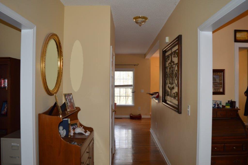 163 Oliver Greene Road Gray, GA 31032 - Photo 4 of 19 a view of a hallway with wooden floor and a livingroom