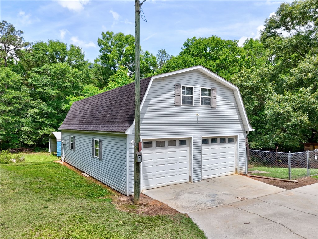 1016 Campbell Road Belton, SC 29627 - Photo 33 of 50 Two-car garage with an upstairs loft offers practical storage and versatile extra space.