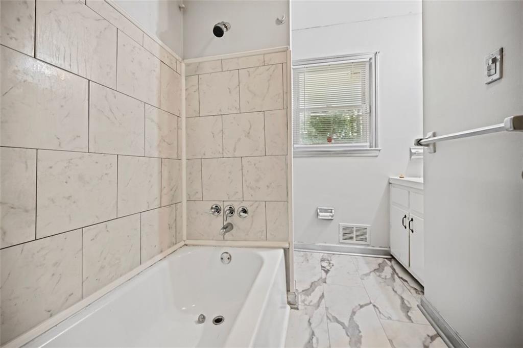 7039 Rockbridge Road Southwest Stone Mountain, GA 30087 - Photo 15 of 28 a bathroom with a bathtub and shower