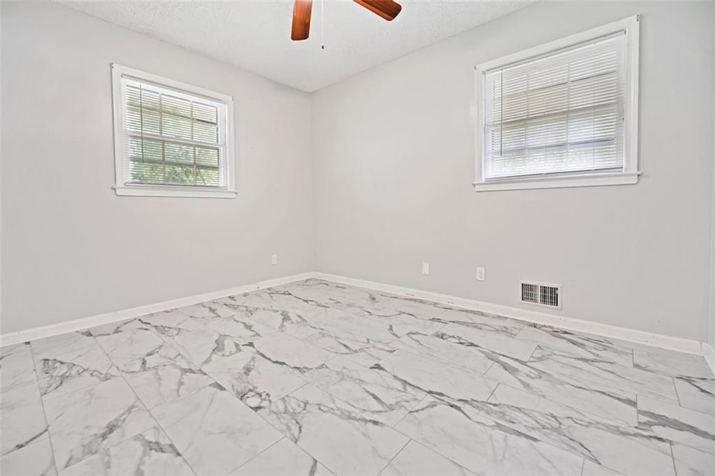 7039 Rockbridge Road Southwest Stone Mountain, GA 30087 - Photo 16 of 28 an empty room with a window