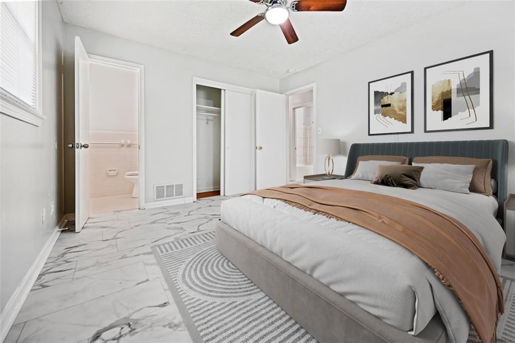 7039 Rockbridge Road Southwest Stone Mountain, GA 30087 - Photo 20 of 28 a bedroom with a large bed and a chandelier